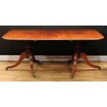 A Regency mahogany twin pedestal dining table, rounded rectangular top with one additional leaf,