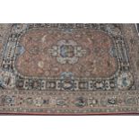 A woollen carpet, worked in the Middle Eastern manner with architectural landscapes, figures,