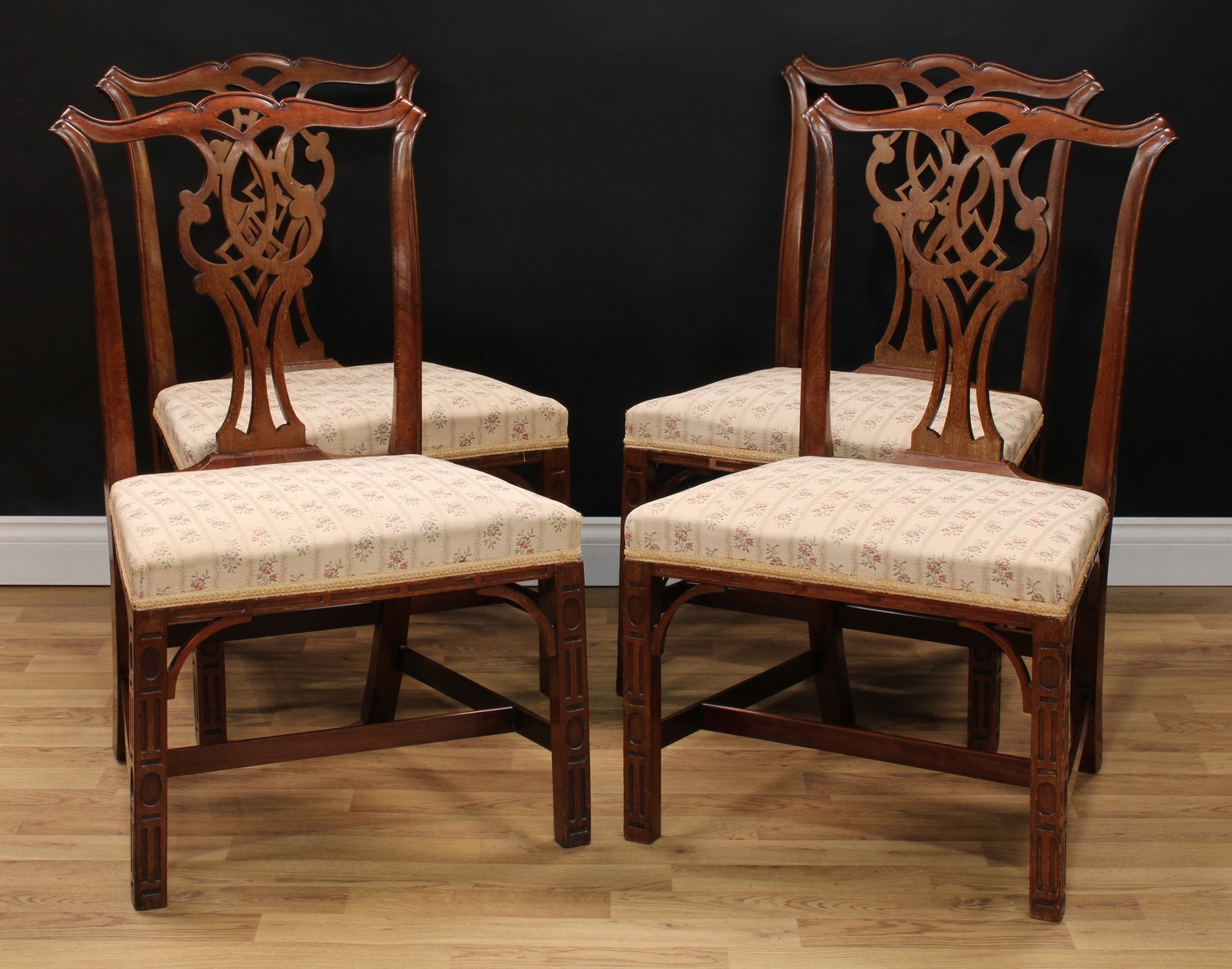 A set of four Chippendale Revival mahogany dining chairs, of broad proportions, each with a cupid'