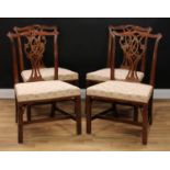 A set of four Chippendale Revival mahogany dining chairs, of broad proportions, each with a cupid'