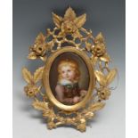 A 19th century German porcelain oval plaque, probably Berlin, of a young boy reading a book, oval,