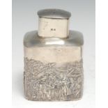 An Edwardian silver rounded square tea caddy, push-fitting cover, chased with scenes in the manner