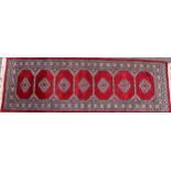 A Middle Eastern woollen runner, worked in the traditional manner, 250cm x 80cm