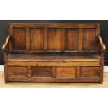 An 18th century oak box settle, rectangular five panel back, downswept arms, turned arm posts,