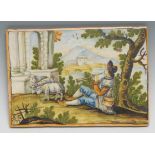 An Italian maiolica rectangular panel, possibly Castelli, painted in polychrome with a shepherd