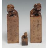 A pair of Chinese soapstone seals, each crested by a temple lion and carved with verse, 13.5cm high;