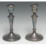 A pair of Elizabeth II silver table candlesticks, urnular sconces, tapered pillars, spreading