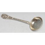 A Victorian cast silver sifter spoon, the leafy stem centred by a mask, pierced circular bowl,