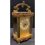 A late 19th century gilt metal serpentine fronted carriage clock, Arabic chapter ring, applied