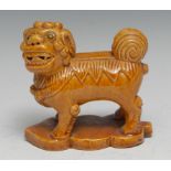 A Chinese monochrome model, of a temple lion, standing four square, leaf shaped base, 11.5cm long,