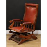 A late 19th century American spring rocking chair, stuffed-over upholstery, ring-turned arm