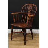 An early 19th century yew and elm Windsor elbow chair, low hoop back, shaped and pierced splat,