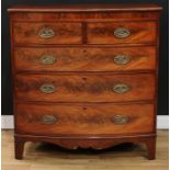 A George IV flame mahogany bow front chest, slightly oversailing top above two short and three