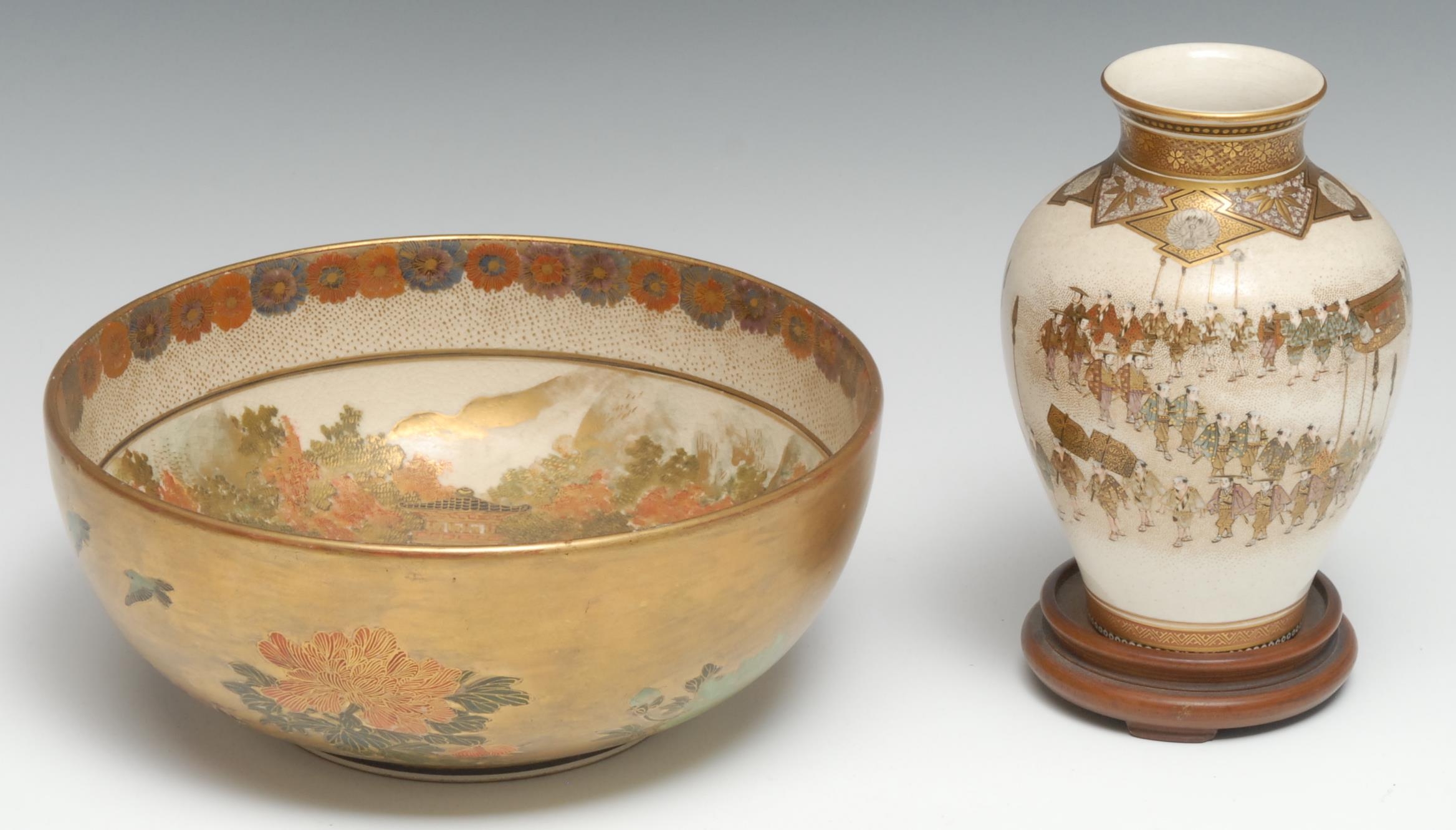 A Japanese Satsuma bowl, decorated with figures and pagodas, in gilt, orange and green, the rim with