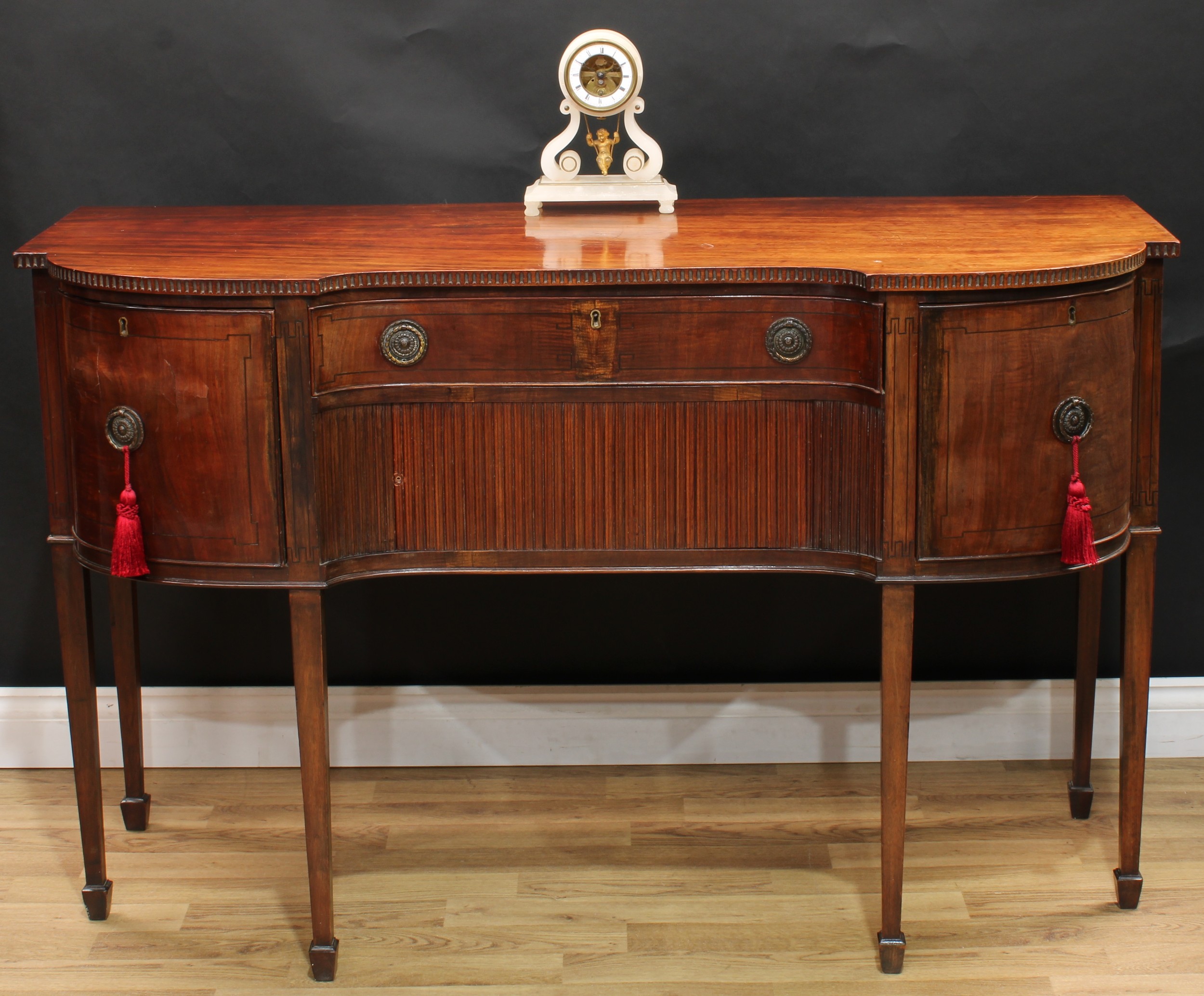 A 19th century mahogany inverted break-centre sideboard, slightly oversailing top with nulled edge