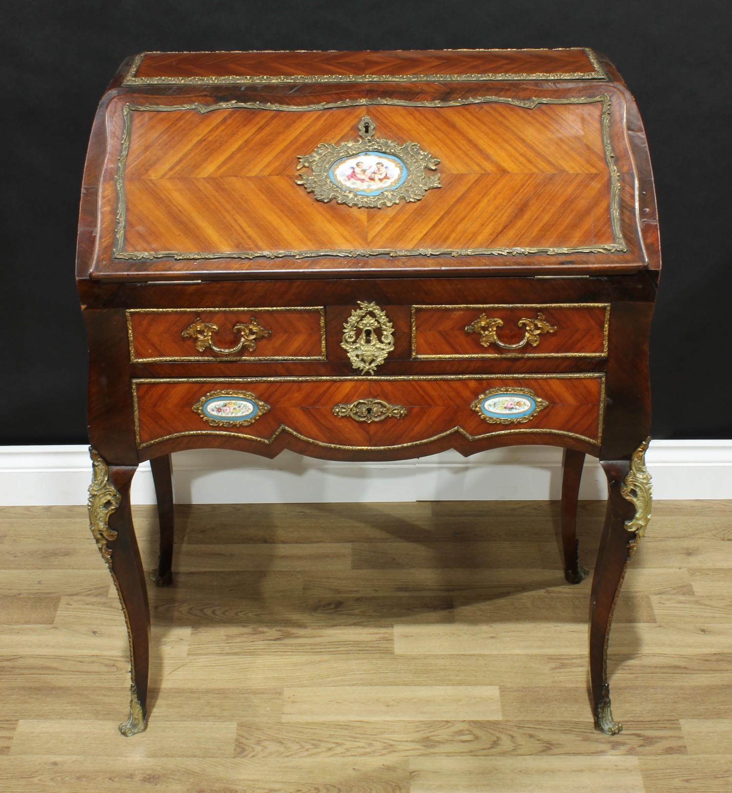 A 19th century French porcelain and gilt metal mounted rosewood bombe-shaped bureau du dame, in