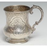 A Victorian silver christening mug, chased and engraved with flowers and stiff leaves within