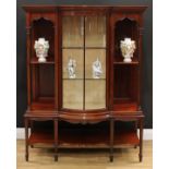 An Edwardian mahogany display cabinet, outswept top with meandrous capital above a glazed door