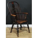 A 19th century elm Windsor elbow chair, hoop back, shaped and pierced splat, saddle seat, turned