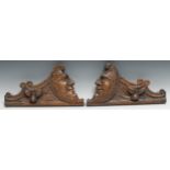 A pair of 19th century oak carved fragments, carved with anthropomorphic crescent moons, facing to