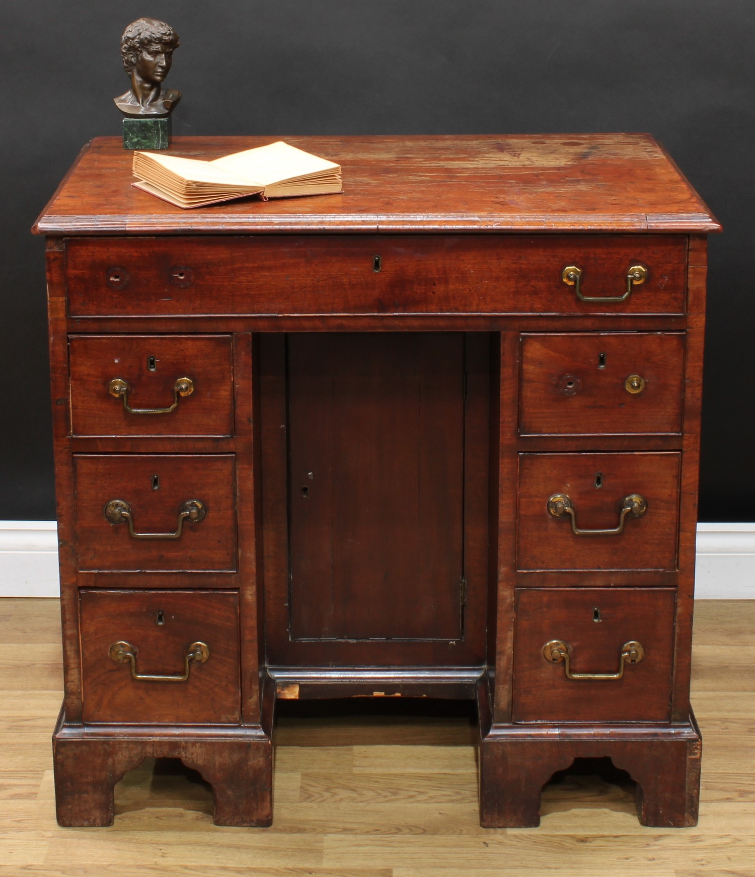 A George III mahogany kneehole desk, rectangular top with moulded edge above a long cockbeaded