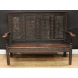 An '18th century' oak Wainscot settle, rectangular four-panel back carved with stylised anthemions