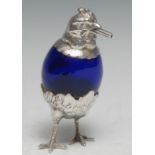 An early 20th century silver coloured metal novelty cigar lighter, as a chicken, blue glass egg