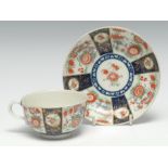 A Worcester teacup and saucer, with alternating blue and kakiemon fan panels, fretted square mark,