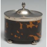 An Edwardian silver mounted tortoiseshell oval tea caddy, hinged cover with fluted knop finial,