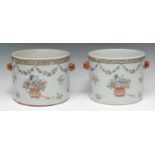 A pair of Chinese cylindrical wine coolers, painted in polychrome with vases of flowers, swags and