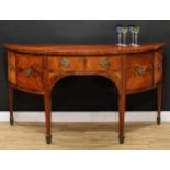 A George III mahogany demilune sideboard or serving table, slightly oversailing top centred by a