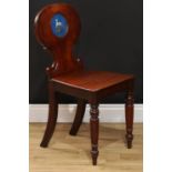 A Victorian mahogany heraldic hall chair, shaped back carved with C-scrolls and polychrome painted