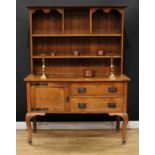 An Arts & Crafts oak dresser, shallow moulded cornice above an arrangement of open shelves, the