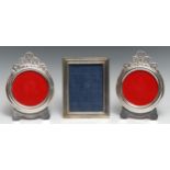 A pair of Egyptian silver circular easel photograph frames, shaped and pierced leafy crestings, 17cm