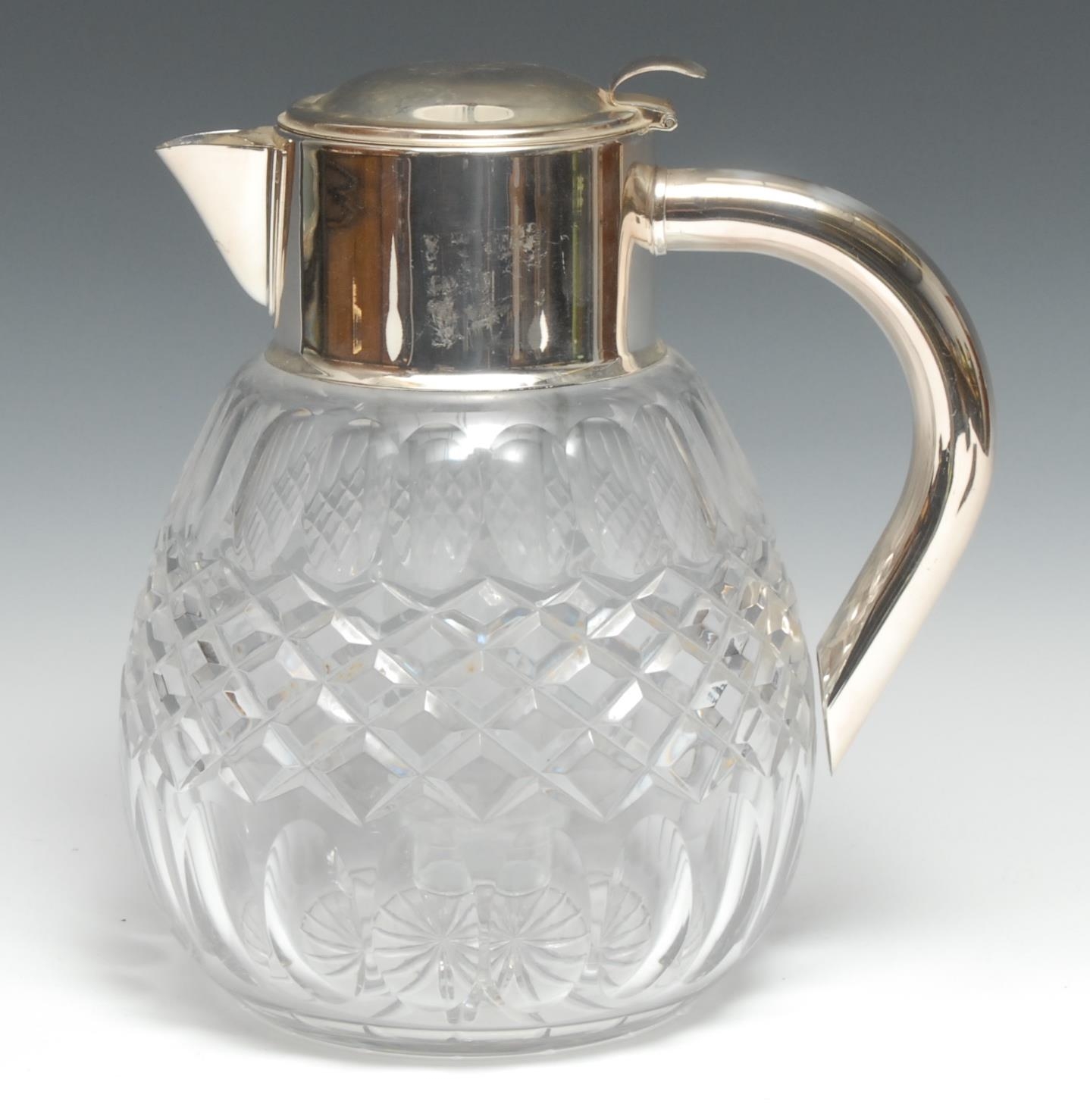 An Edwardian style silver plate mounted clear glass ovoid lemonade jug, hinged cover enclosing a