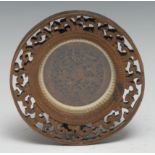 A Chinese sandalwood roundel, carved in relief with traditional figures, blossom, and garden