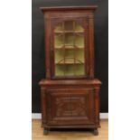 An 18th century Continental oak display cabinet, outswept cornice above an astragal glazed door