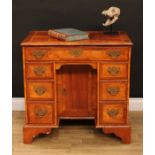 A George II Revival walnut kneehole desk, rectangular top with moulded edge above a long frieze