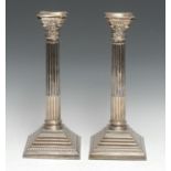 A pair of George III style silver Corinthian column table candlesticks, detachable nozzles, stop-