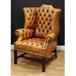 A George III design Chesterfield wingback armchair, studded stuffed-over deep button upholstery,