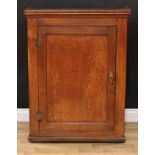 A George III oak provision cupboard, moulded cornice above a rectangular panel door enclosing