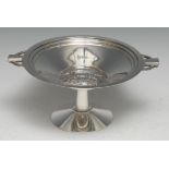An Art Deco silver pedestal tazza, the field in relief with a dog, pierced geometric lug handles,