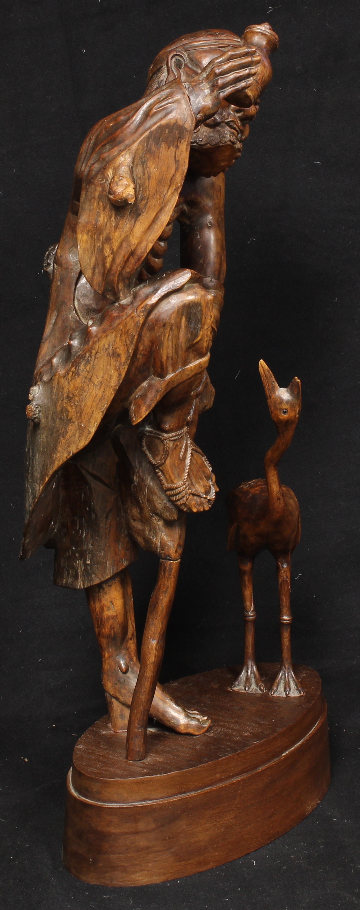 A large Japanese rootwood figure, carved as an emaciated elder beside a crane, oval base, 82cm high, - Image 2 of 4