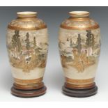 A pair of Japanese Satsuma vases, decorated with a continuous scene of figures in a landscape, 19.