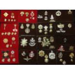 A collection of British Army Staybritie Cap badges and modern metal issue cap badges comprising