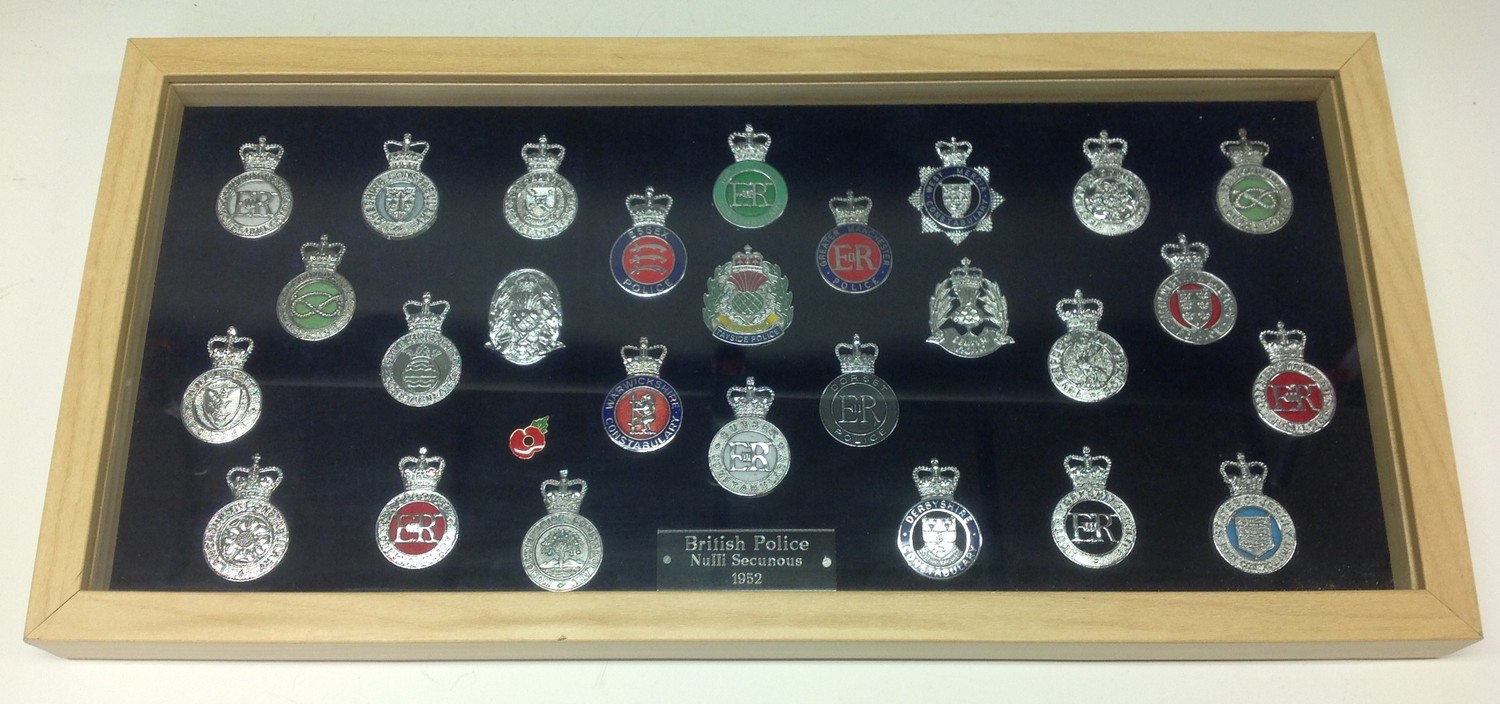 A collection of framed British Police cap badges entitled "British Police 1952" along with Motto "