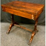 A Victorian rosewood side table, with folding top, drawer to frieze, twin columns, turned stretcher,