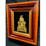 A 19th century gilt metal plaque, of a Highlander, seated playing his bagpipes, framed, 36m x 33cm