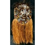 A Papua New Guinea sepik ceremonial mask, carved and painted face, adorned with shells and feathers,