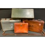 An large rectangular leather suit case, adorned with shipping labels in Delta, USA, Paris etc;